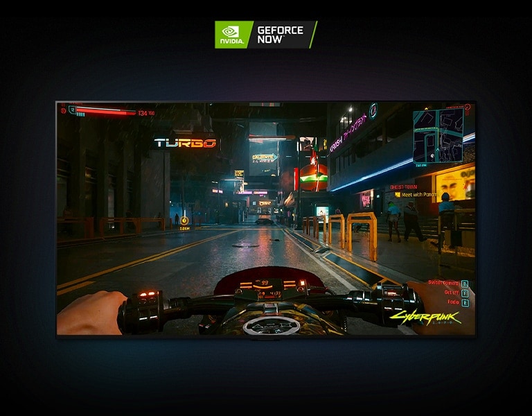 I en scen från Cyberpunk 2077 som visas på en LG OLED-skärm kör spelaren på en motorcykel genom en neonupplyst gata