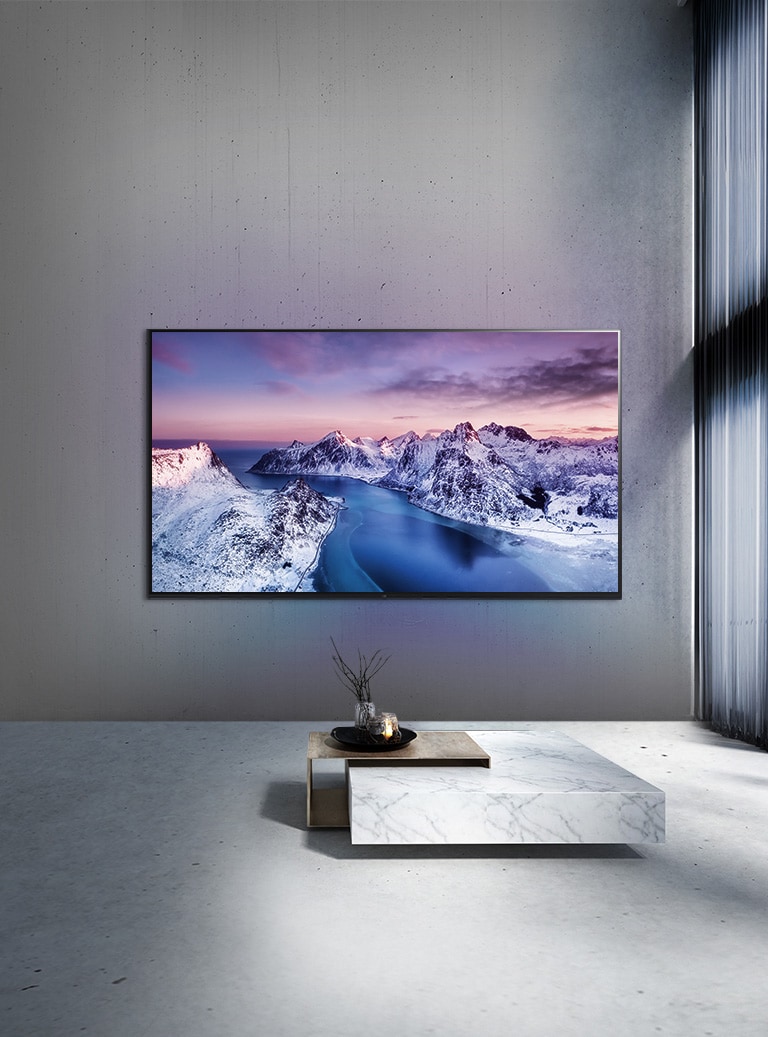 En UHD TV monterad på väggen bakom ett bord i minimalistisk stil.
