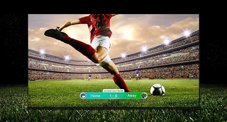 En bild av displayen som visar en fotbollsmatch med en spelare i rött ställ som ska sparka bollen över stadion. Ställningen i matchen visas längst ner på skärmen. Det gröna gräset från planen sträcker sig utanför skärmen till den svarta bakgrunden.