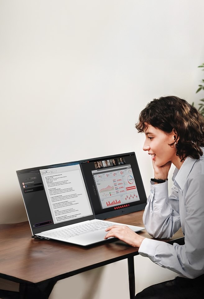 En kvinna använder en LG gram-laptop med dubbelskärmsinställning för videokonferens och multitasking i sitt hemmakontor.