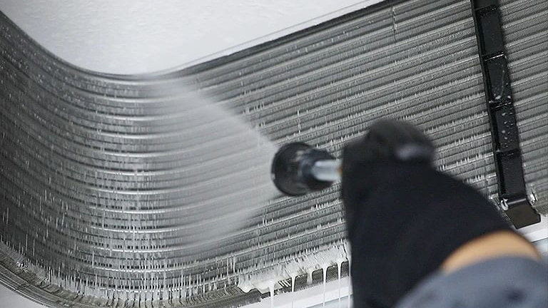 An engineer is cleaning the inside of the cassette air conditioner.