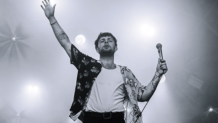 A musician standing on a stage with the spotlight on him