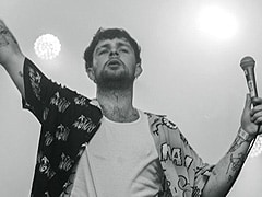 A musician standing on a stage with the spotlight on him