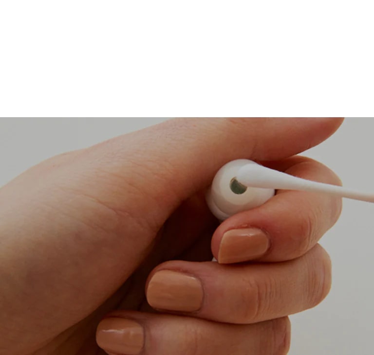 An image of holding the earbuds in hand and wiping the earbuds with a cotton swab, expressing the severity of the bacteria contained in the earbuds.