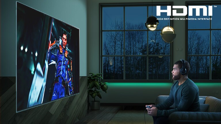 Man sitting on a sofa, holding a joystick while playing a RPG game on a TV screen