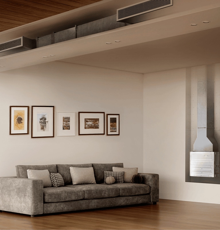 Modern living room with grey sectional sofa, wall art, visible HVAC duct, wood accents, and window view of greenery.