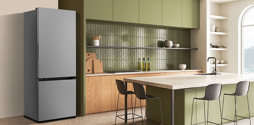 The side view of lg bottom freezer refrigerator with water dispenser with green cabinets and a stylish island.