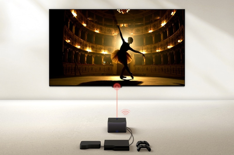 A Zero Connect Box in front of an LG OLED evo M4, and a red Wi-Fi signal and red beam emitting towards the TV. The TV displays a ballerina dancing solo on stage.
