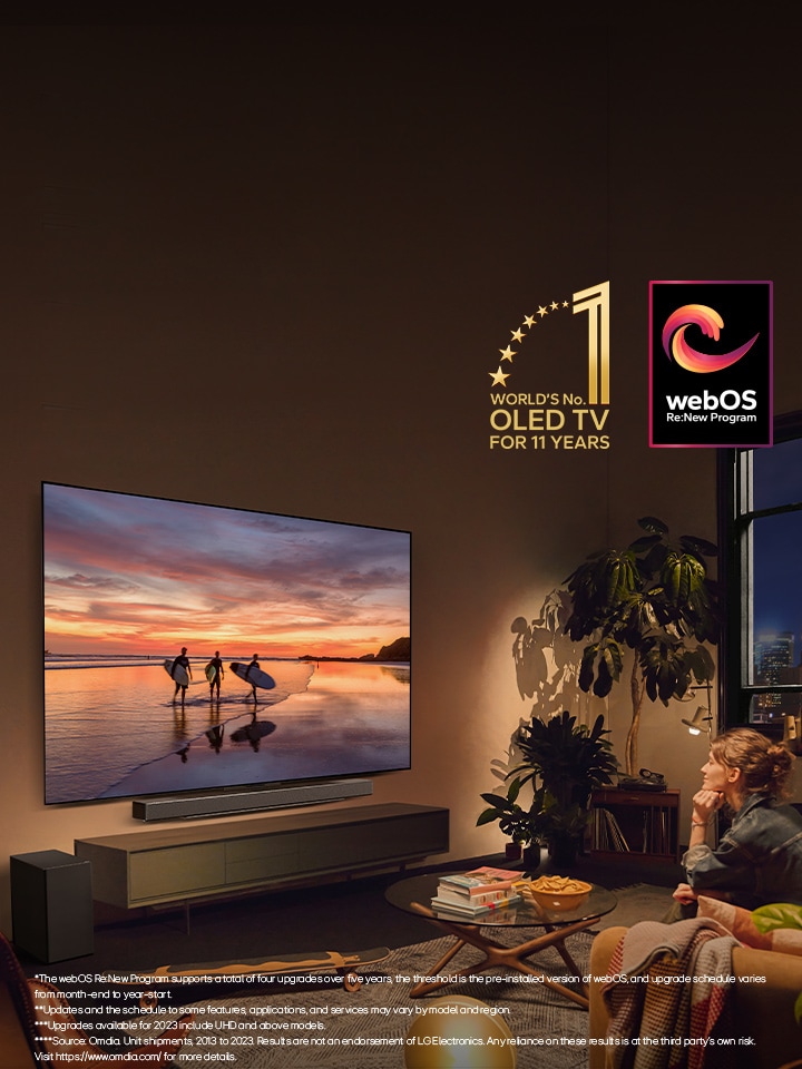 LG OLED evo AI C4 TV mounted on the wall of a cosy evening living room and an LG soundbar mounted just below it. On the TV, a beach at sunset with silhouttes of three surfers is displayed. Two women sit on the sofa facing and leaning towards the TV and soundbar. The "World's number 1 OLED TV for 11 Years" emblem and the "webOS Re:New Program" logo are in the image. A disclaimer reads: "The webOS Re:New Program supports a total of four upgrades over five years, the threshold is the pre-installed version of webOS, and upgrade schedule varies from month-end to year-start." "Updates and the schedule to some features, applications, and services may vary by model and region." "Upgrades available for 2023 include UHD and above models." "Source: Omdia. Unit shipments, 2013 to 2023. Results are not an endorsement of LG Electronics. Any reliance on these results is at the third party’s own risk. Visit https://www.omdia.com/ for more details."