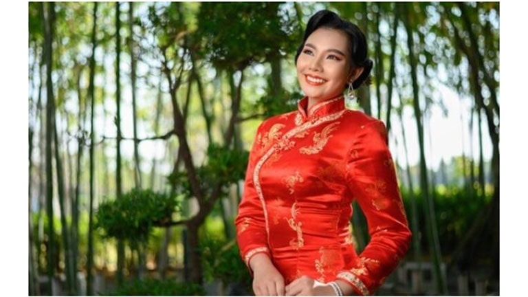 ผู้หญิงสวมชุดจีนโบราณสีแดงยืนในป่าไผ่