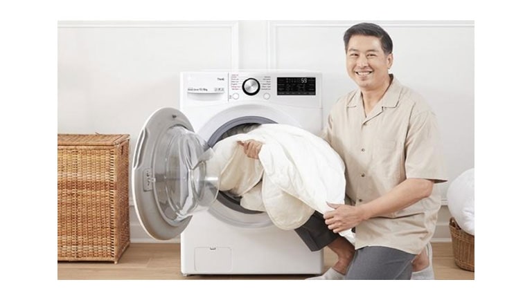 ผู้ชายกำลังหยิบผ้าออกจากเครื่องซักผ้าฝาหน้า งบประมาณ