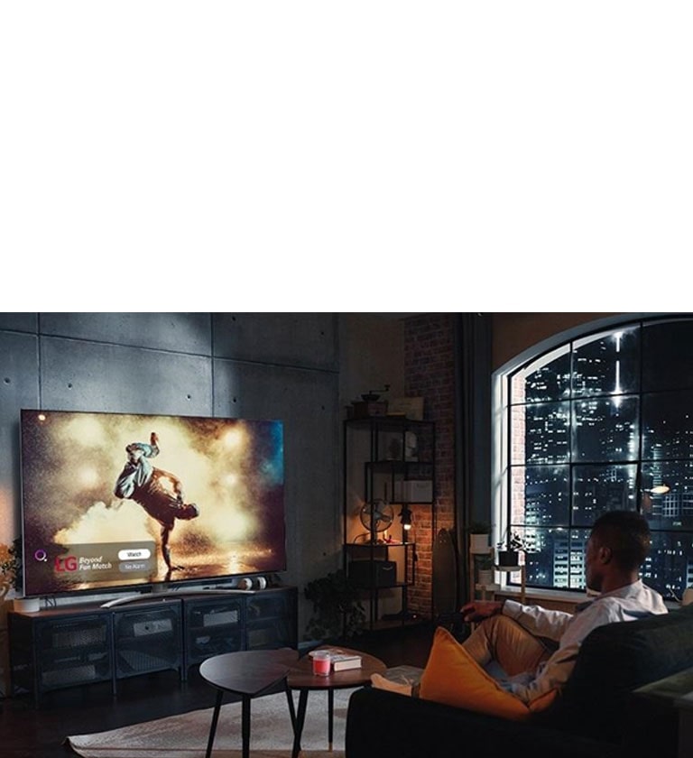 ผู้ชายกำลังนั่งดูหนังผ่านทีวี LG