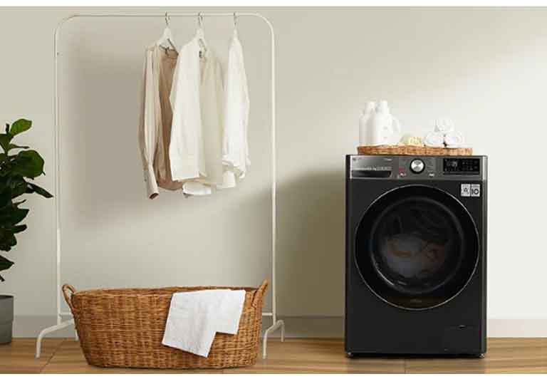 เครื่องซักผ้าอบผ้าวางอยู่ข้างตะกร้าผ้าและราวตากผ้า