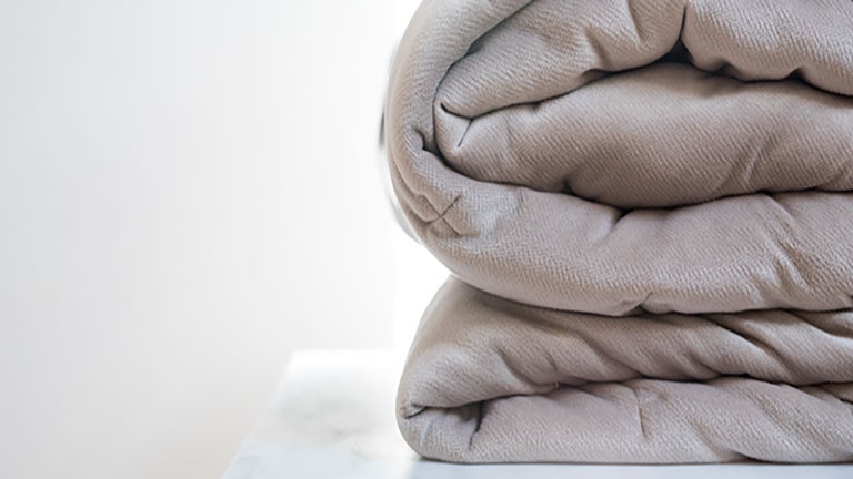 ผ้านวมหนาพับวางไว้รอซัก