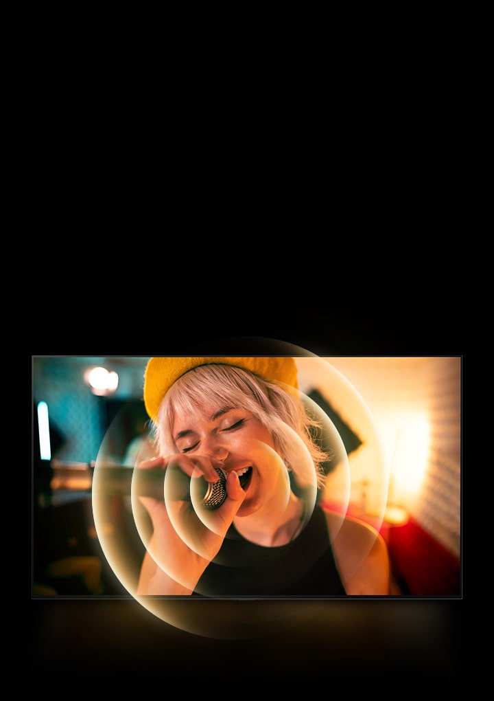 ผู้หญิงคนหนึ่งร้องเพลงโดยมีไมโครโฟนอยู่ในมือ เนื่องจากมีกราฟิกวงกลมสีส้มรอบๆ ปากเพื่อแสดงภาพเสียง