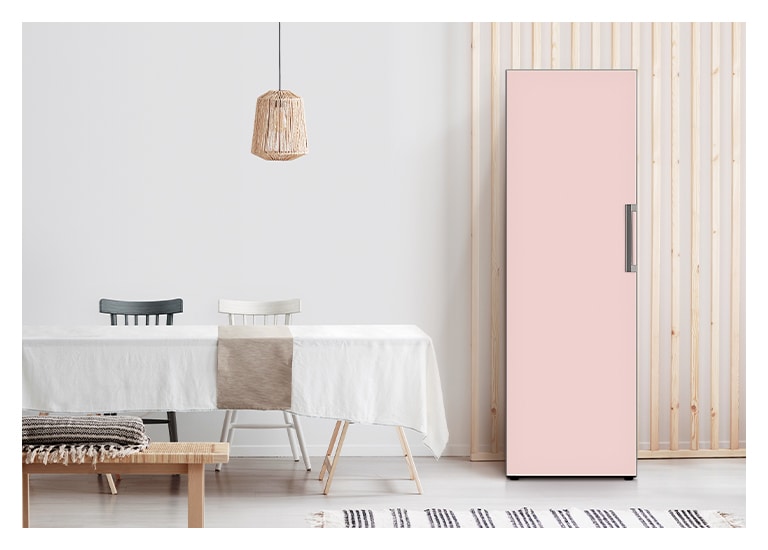 It shows mist pink color Freezer placed in the kitchen that matches naturally to the furniture around..