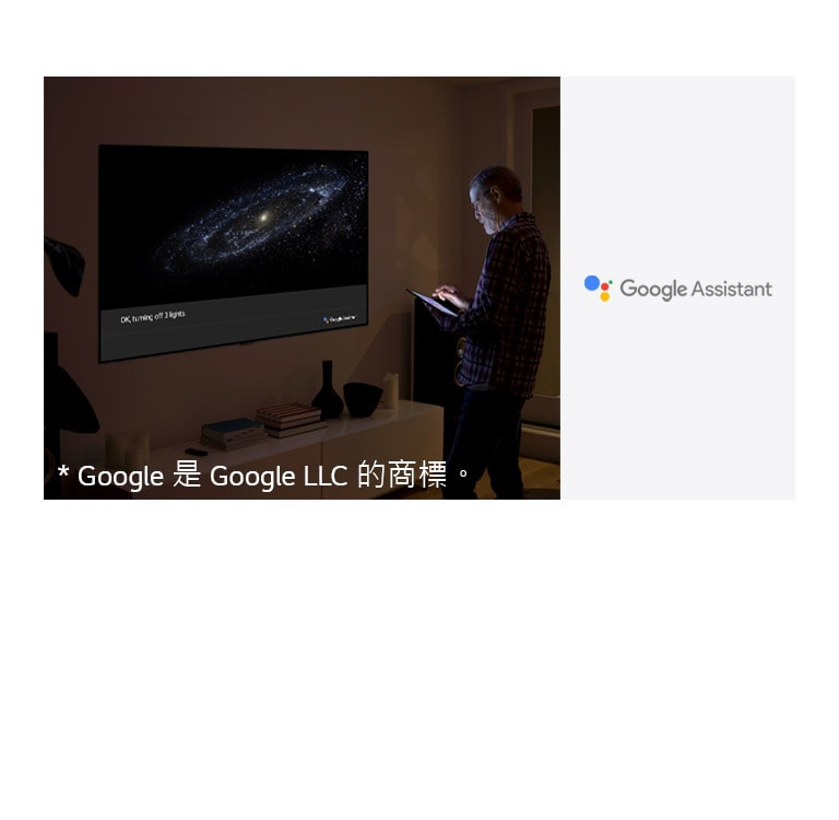 A man is standing in front of TV and ask google assistant to turn off the light