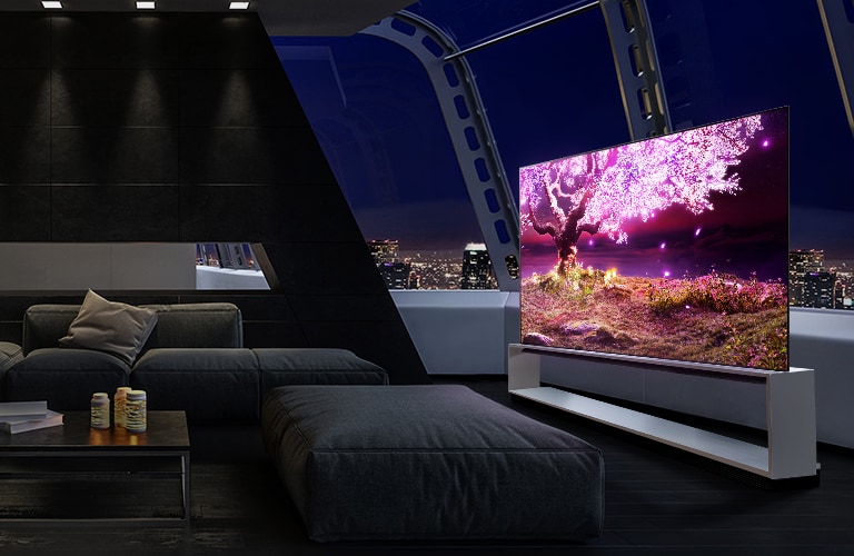 架子上的電視顯示一棵樹在黑暗和現代的房屋環境中發出粉紅色的光