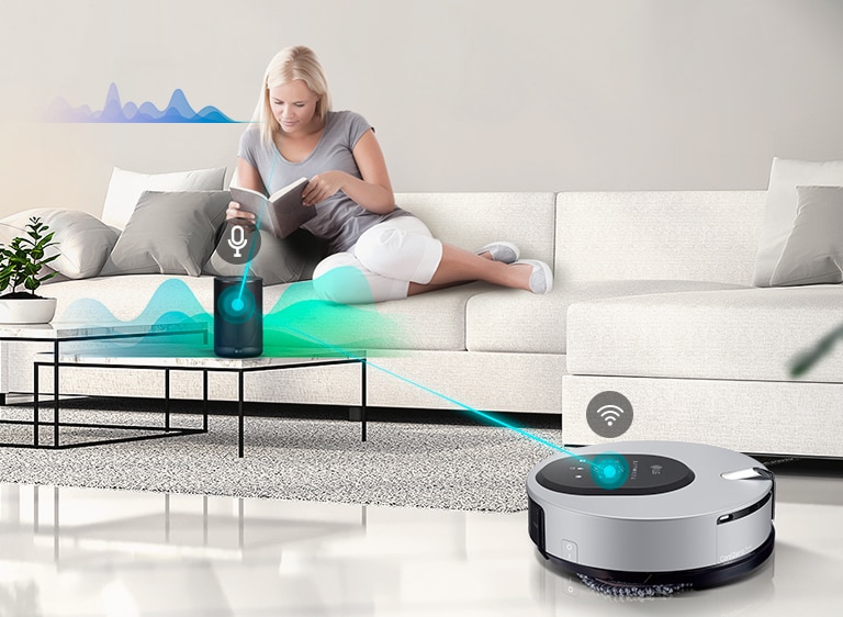 Three icons at the top indicate there are three images in a carousel. The first icon, labelled "Voice Control", is red. A woman sits on a couch reading in the background as the machine is in the foreground. A blue line is drawn between the machine and an AI speaker that has listened to the woman and is directing the mop. Wave lines are drawn near the woman to indicate speaking and near the AI speaker to indicate directing the machine.