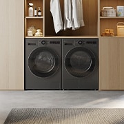 This lifestyle image shows LG RHX7010TBB 10 10kg DUAL Inverter Heat Pump™ Dryer, Black, along side an LG Laundry machine in black, the environment looks nice and cozy with natural colour theme