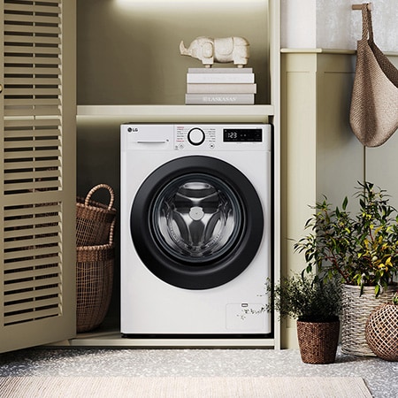 The white LG 11kg washing machine F4Y511WBLN1, featuring a distinctive black porthole ring, shown installed in a stylish, modern laundry closet.