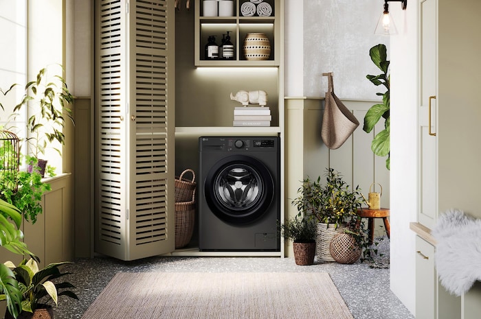The LG 10kg washing machine F4Y510GBLN1 in Slate Grey, featuring its premium design, shown installed in a stylish, modern laundry closet.