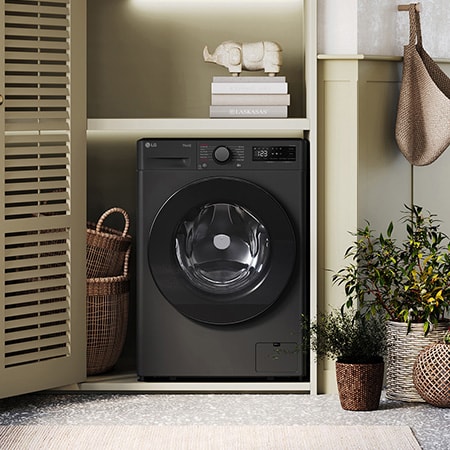 The LG 9kg Counter-Depth MAX™ washing machine F2A509GBLN1 in Slate Grey, installed in a stylish, modern laundry closet.
