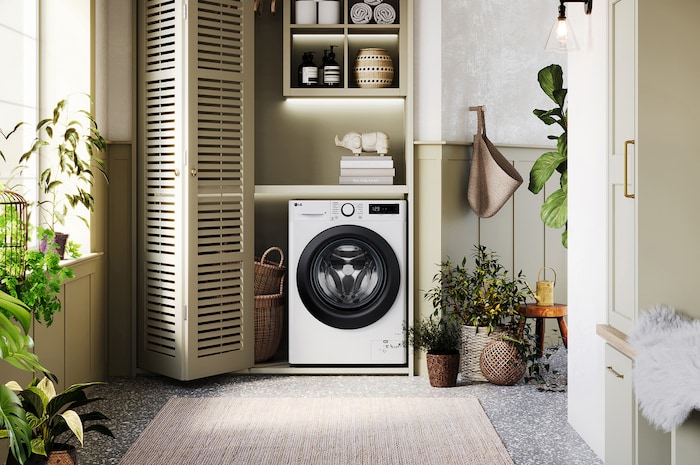 The white LG 9kg Slim washing machine F2Y509WBLN1, featuring a distinctive black porthole ring, shown installed in a stylish, modern laundry closet.