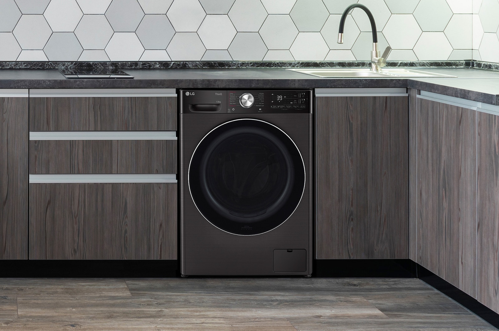 The Platinum Black LG 13kg washing machine F4Y913BCTA1, shown neatly installed under a counter in a modern kitchen.