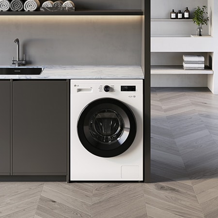 The LG 9kg washing machine F4X1008NWK in Essence White, shown built-under a counter in a modern laundry room.