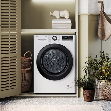 The white LG 9kg dryer FDC309W, featuring a distinctive black porthole ring, shown installed in a stylish, modern laundry closet.