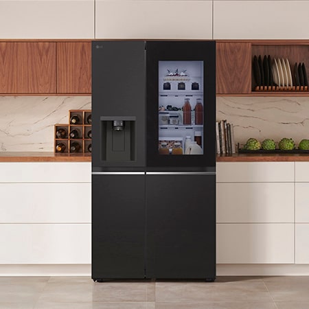 LG Side-by-Side Refrigerator GSGV81EPLD in a matte black steel finish, featuring InstaView™ Door-in-Door® and a dispenser, integrated into a modern kitchen with white and wood cabinets.