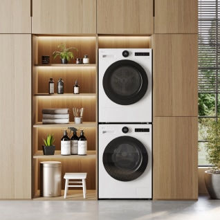 In the laundry room next to the living room, a black LG washing machine is placed inside a wood-tone cabinet.	