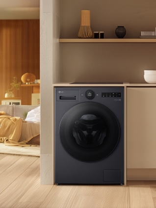 In the laundry room next to the living room, a black LG washing machine is placed inside a wood-tone cabinet.	