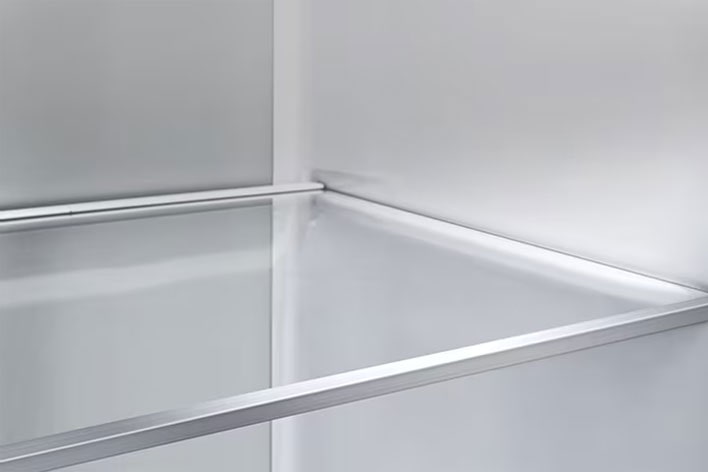 A diagonal view of the shelf with metallic paneling on the interior of the refrigerator.