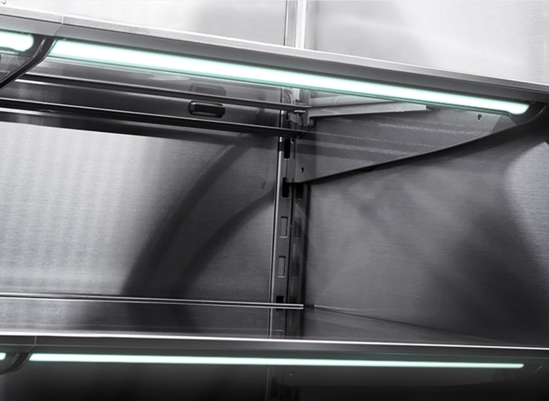 Close horizontal shot of the stainless inner walls of LG SIGNATURE Refrigerator with the blue lights turned on.