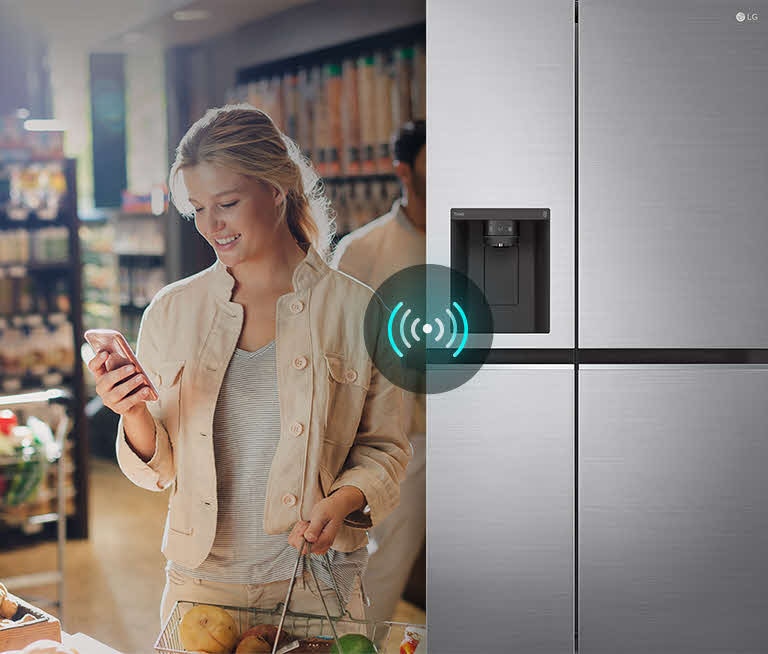 Image on the left shows a woman standing in a grocery store looking at her phone. Image on the right shows the refrigerator front view. In the center of the images is an icon to show connectivity between the phone and refrigerator.