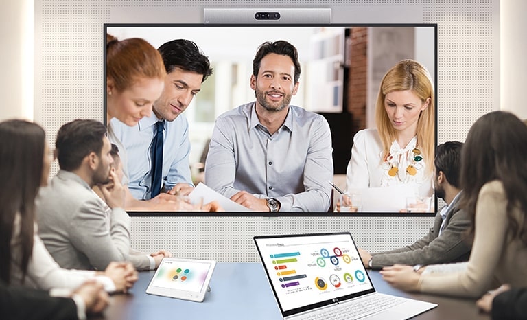A video conference is being held as people are screened on signage installed on the wall.