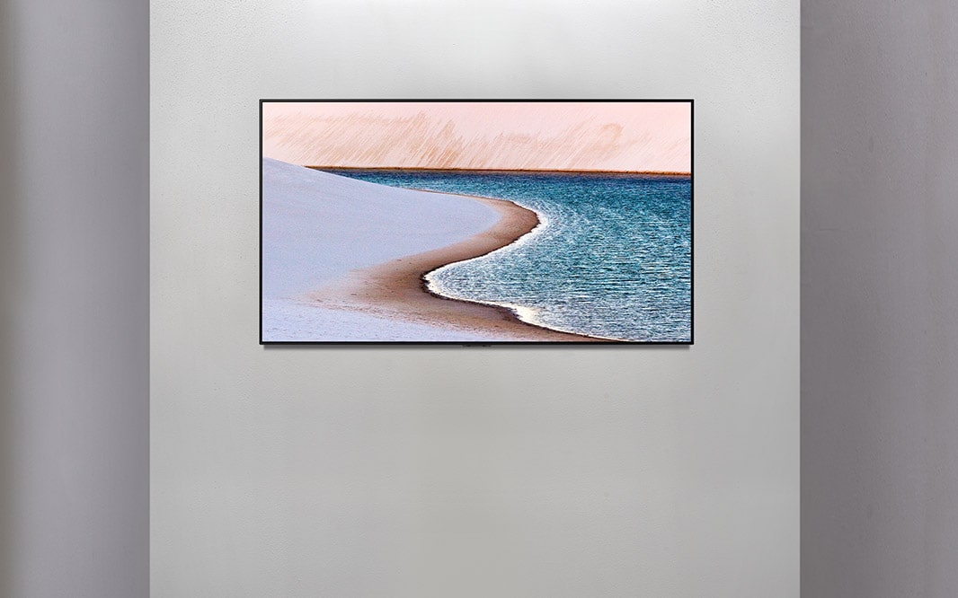 TV on a wall showing an image of the seashore