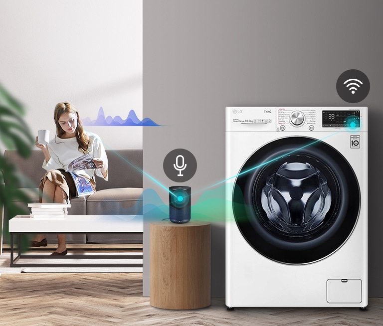 A woman sitting on the couch and drinking tea is giving orders to her washing machine through her AI speaker.