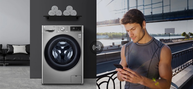 A man outdoors is checking the condition of a washing machine at home through a mobile phone app.
