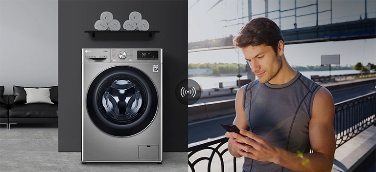 A man outdoors is checking the condition of a washing machine at home through a mobile phone app.