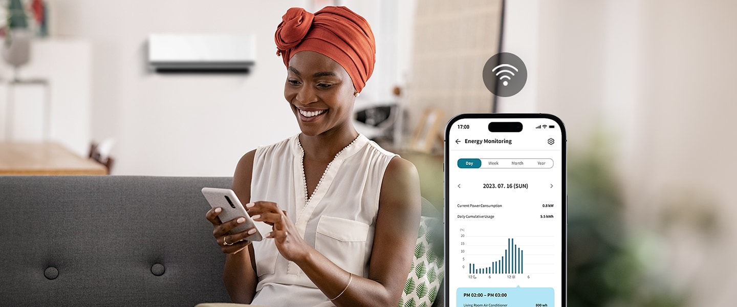 A woman enjoying the cool air conditioner wind is checking the energy usage of the air conditioner through the ThinQ™ app screen.	