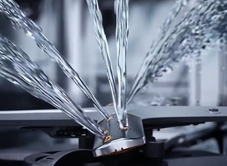 Intense water streams from dishwasher blades in close-up.	