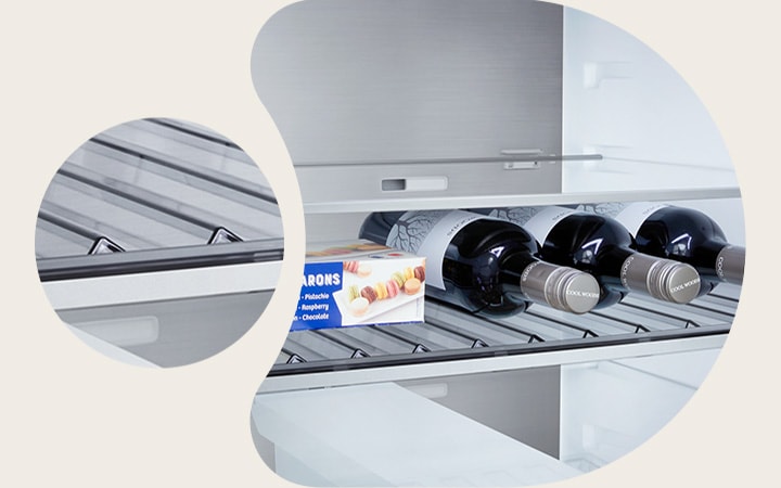 LG fridge freezer (GBBS726CEV) close up of wine rack holding four bottles and box of macarons with rack design magnified in circular image