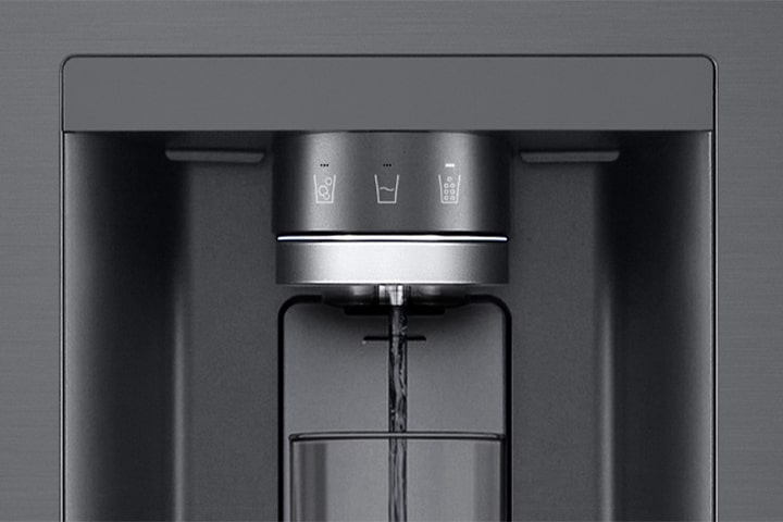 A video starts zoomed in on the water dispenser. The exterior of the refrigerator goes clear and now the interior of the door and mechanical parts of the dispenser nozzle can be seen. The video zooms in further to show the water droplets as they fall through the UVnano part of the nozzle which reduces the bacteria. The view zooms back out to see the exterior of the refrigerator again as water is being dispensed into a glass.