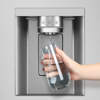 A person is getting water from the refrigerator dispenser in a cup