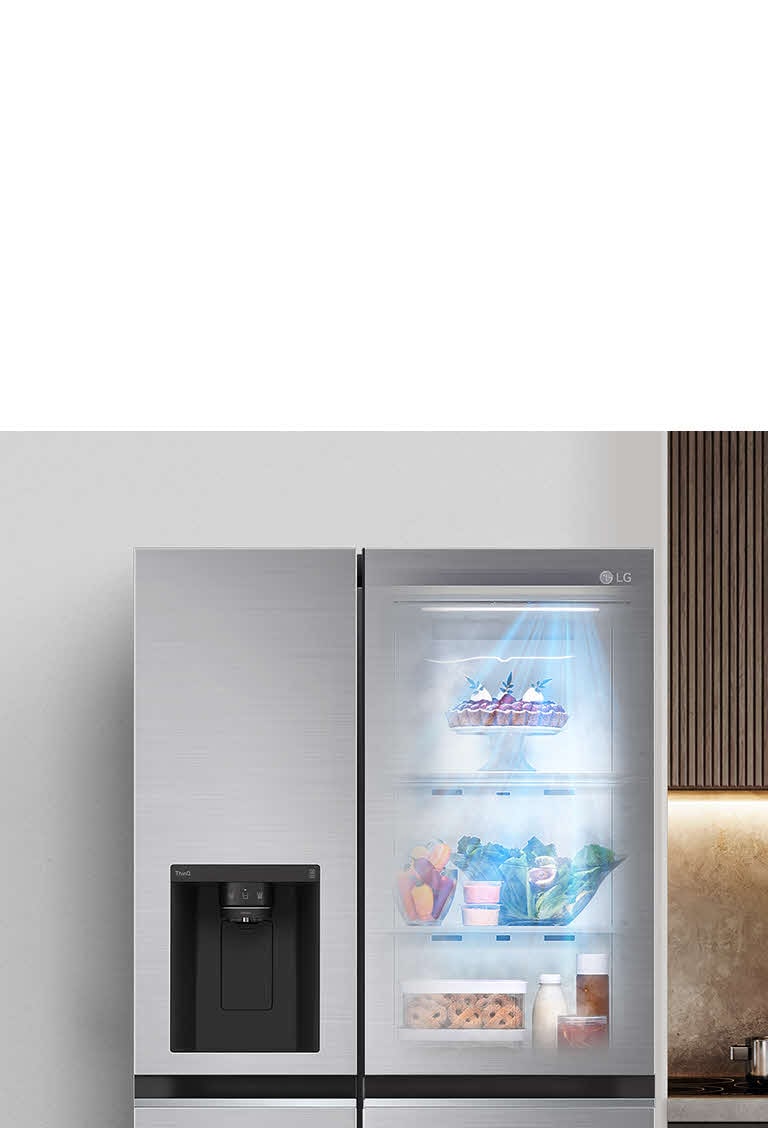 LG refrigerator with transparent door shows food items, left of stove.