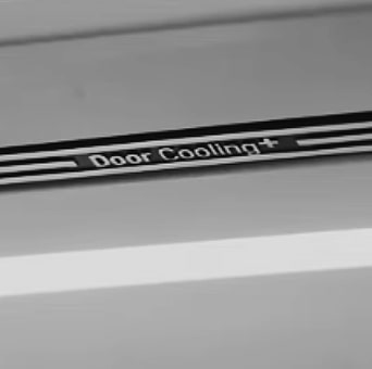 Une personne prend de l’eau du distributeur du réfrigérateur dans un verre