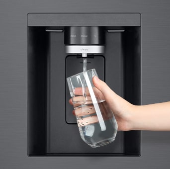 A person is getting a cup of water from lg multi door refrigerator's water dispenser.